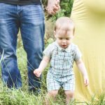 man in black tank top carrying baby in blue and white plaid button up shirt