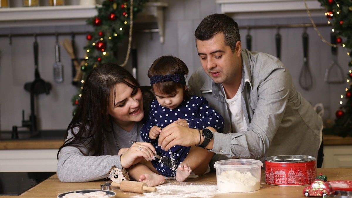 a man, woman and child sitting at a table in a kitchen